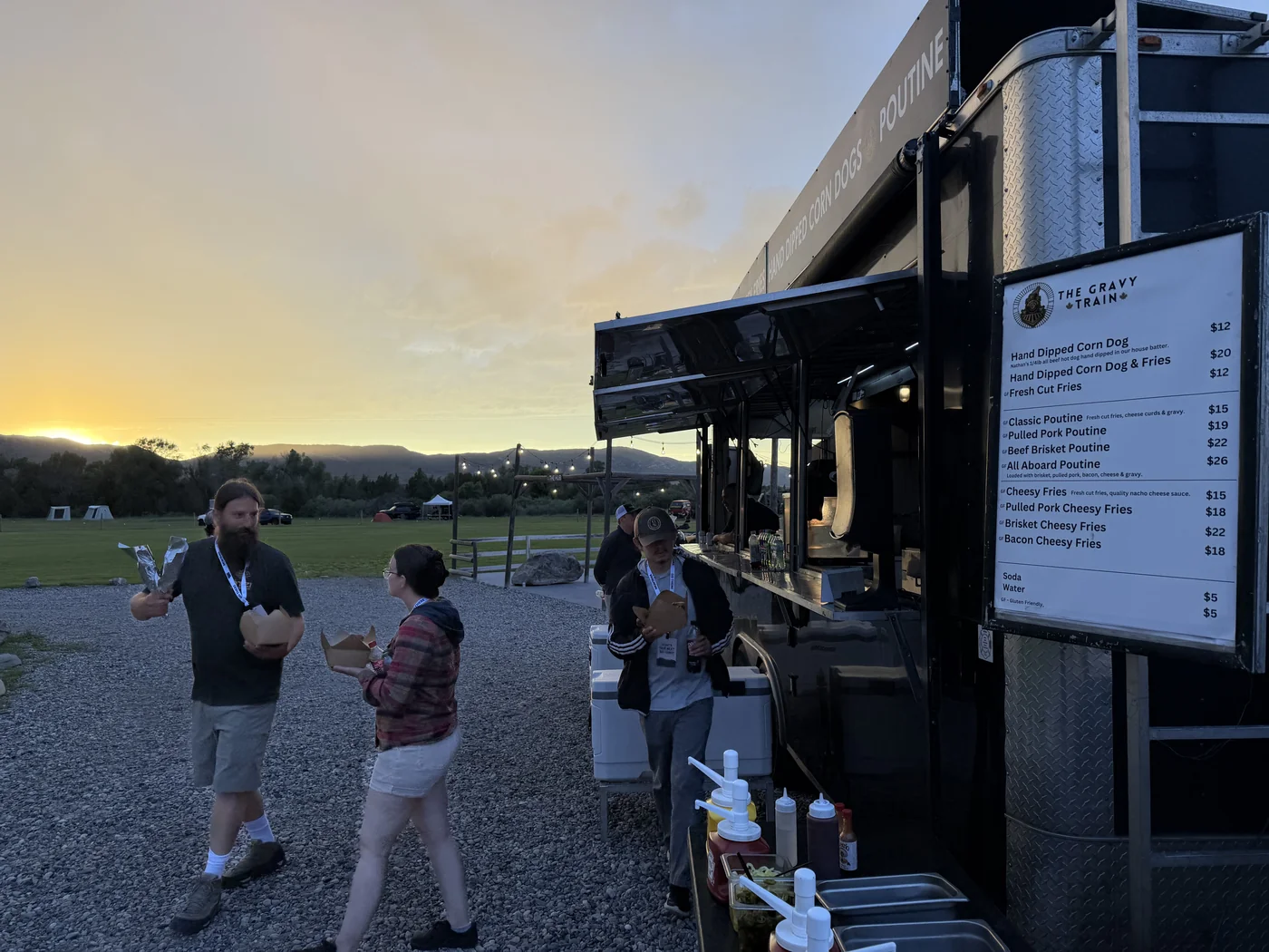 Customers ordering from The Gravy Train menu board at sunset at The Big Thing
