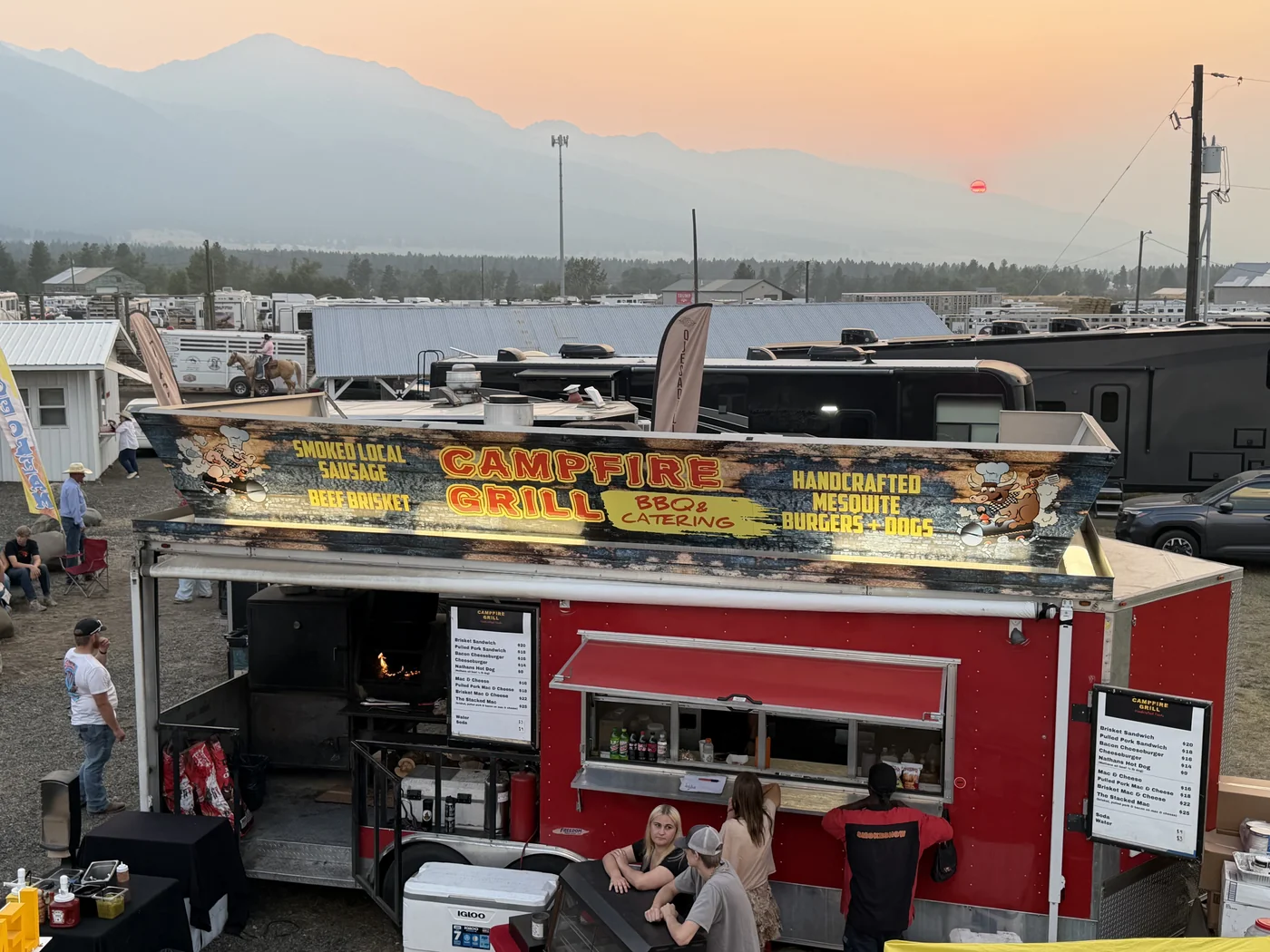 Campfire Grill with the Wallowa Mountains and a horse in the background at Chief Joseph Days Rodeo
