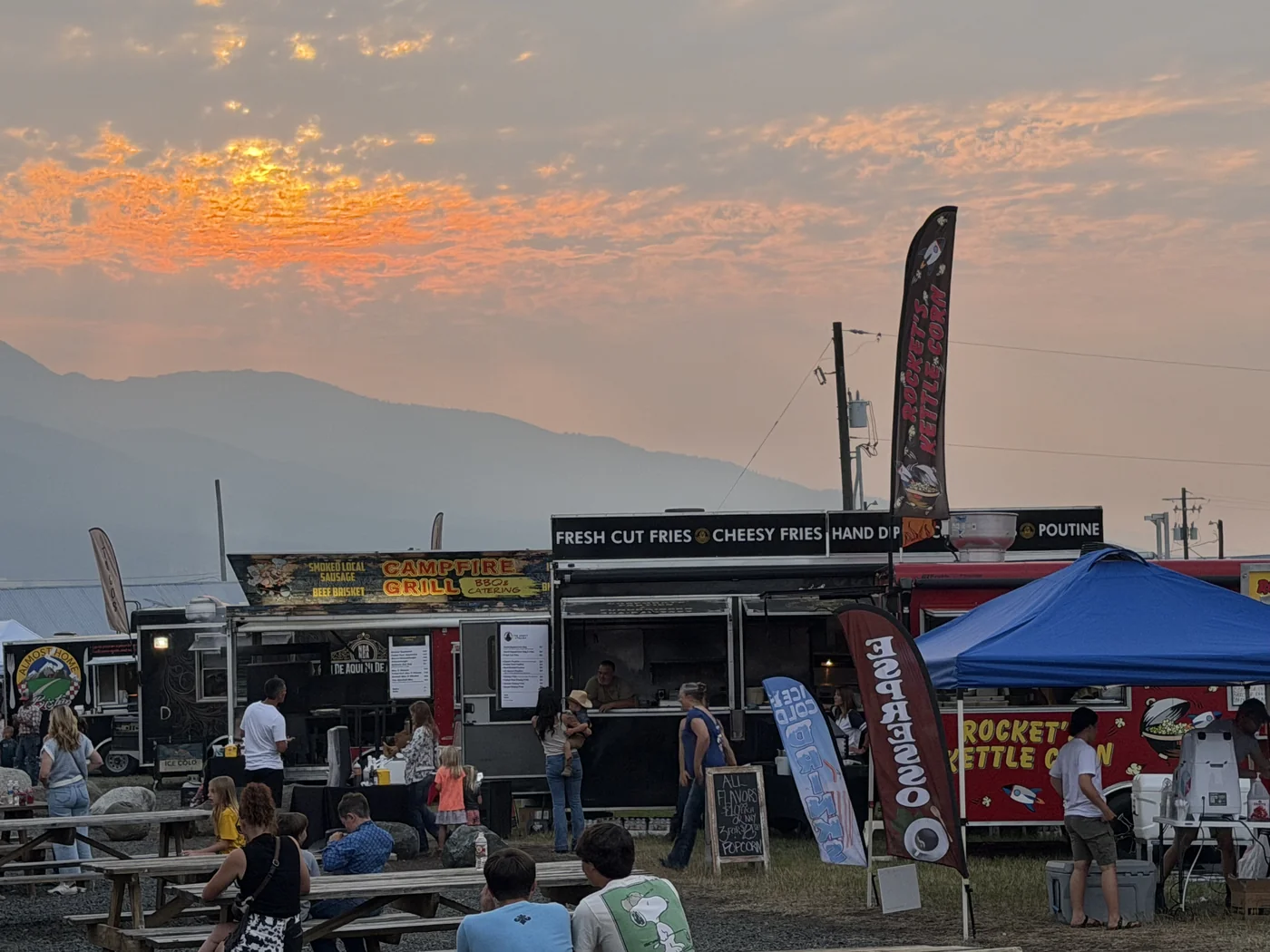 Food truck court under a dramatic orange sunset at Chief Joseph Days Rodeo