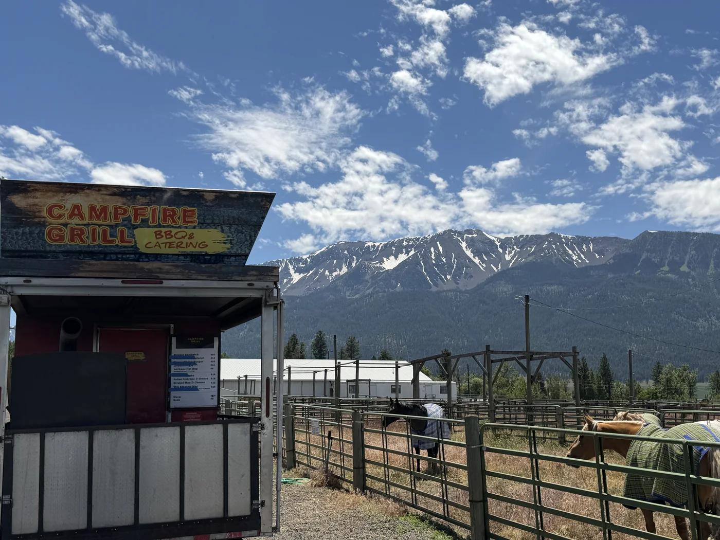 Campfire Grill truck alongside the rodeo arena with horses and mountains at Mountain High Broncs & Bulls