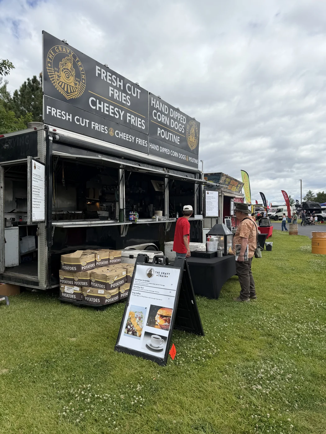The Gravy Train menu board with fresh potato boxes stacked at Overland Expo PNW