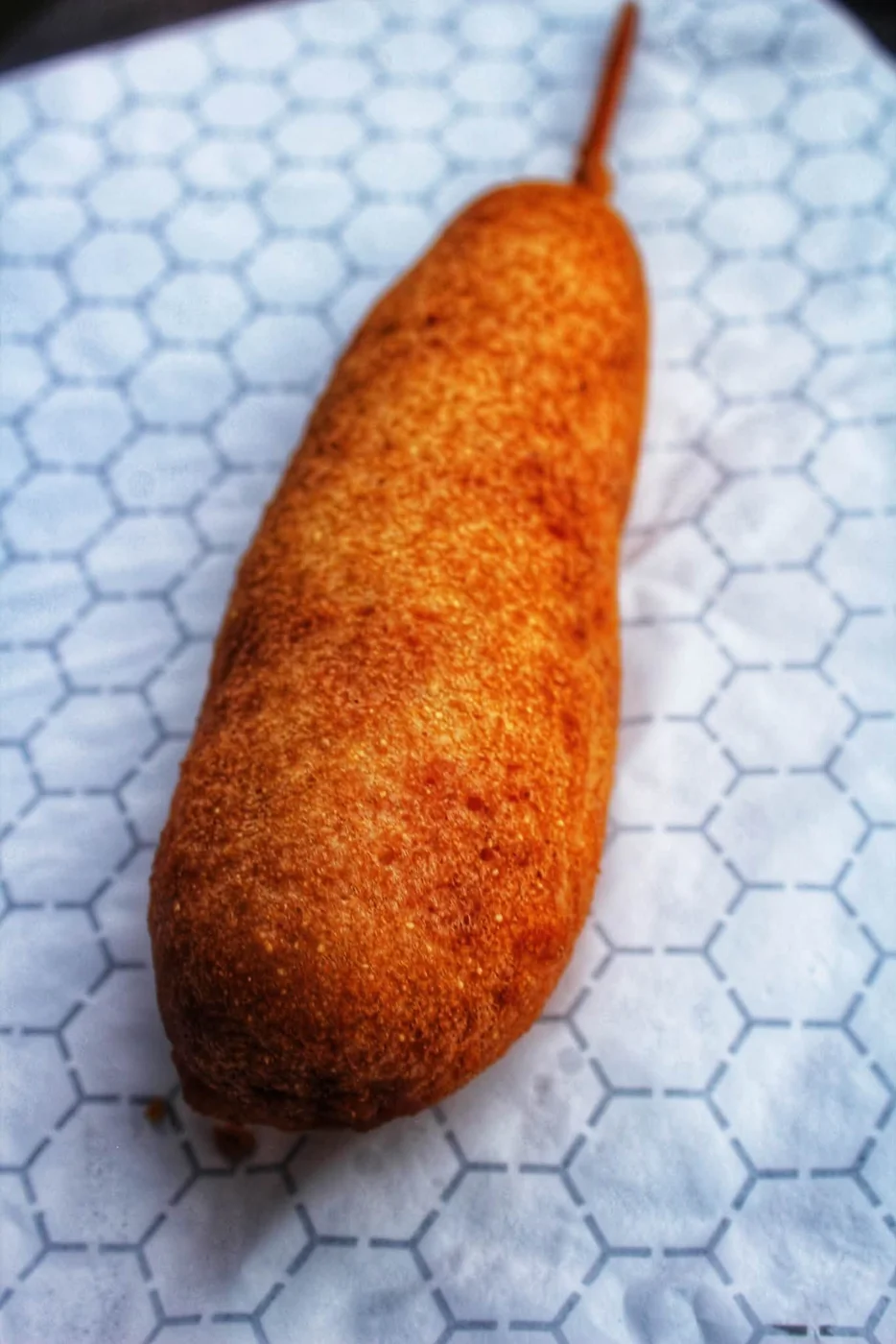 Hand-dipped corn dog on hex-pattern paper
