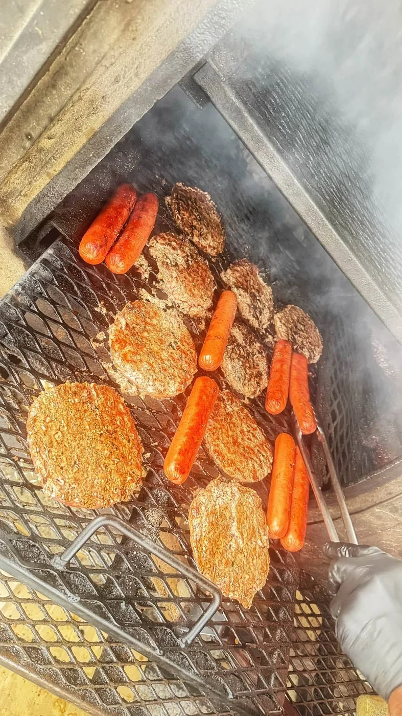 Burger patties and hot dogs on the open grill