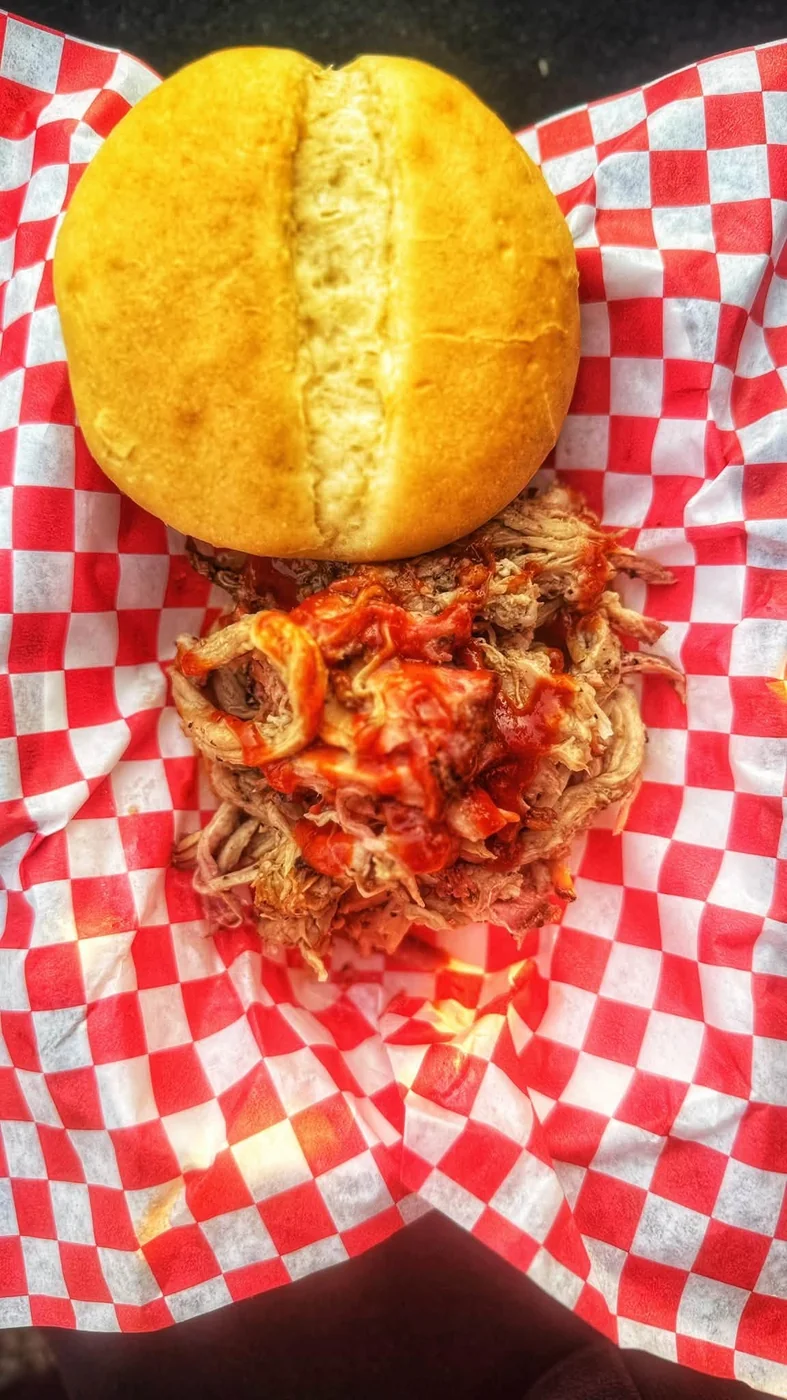 Pulled pork sandwich on red checkered paper